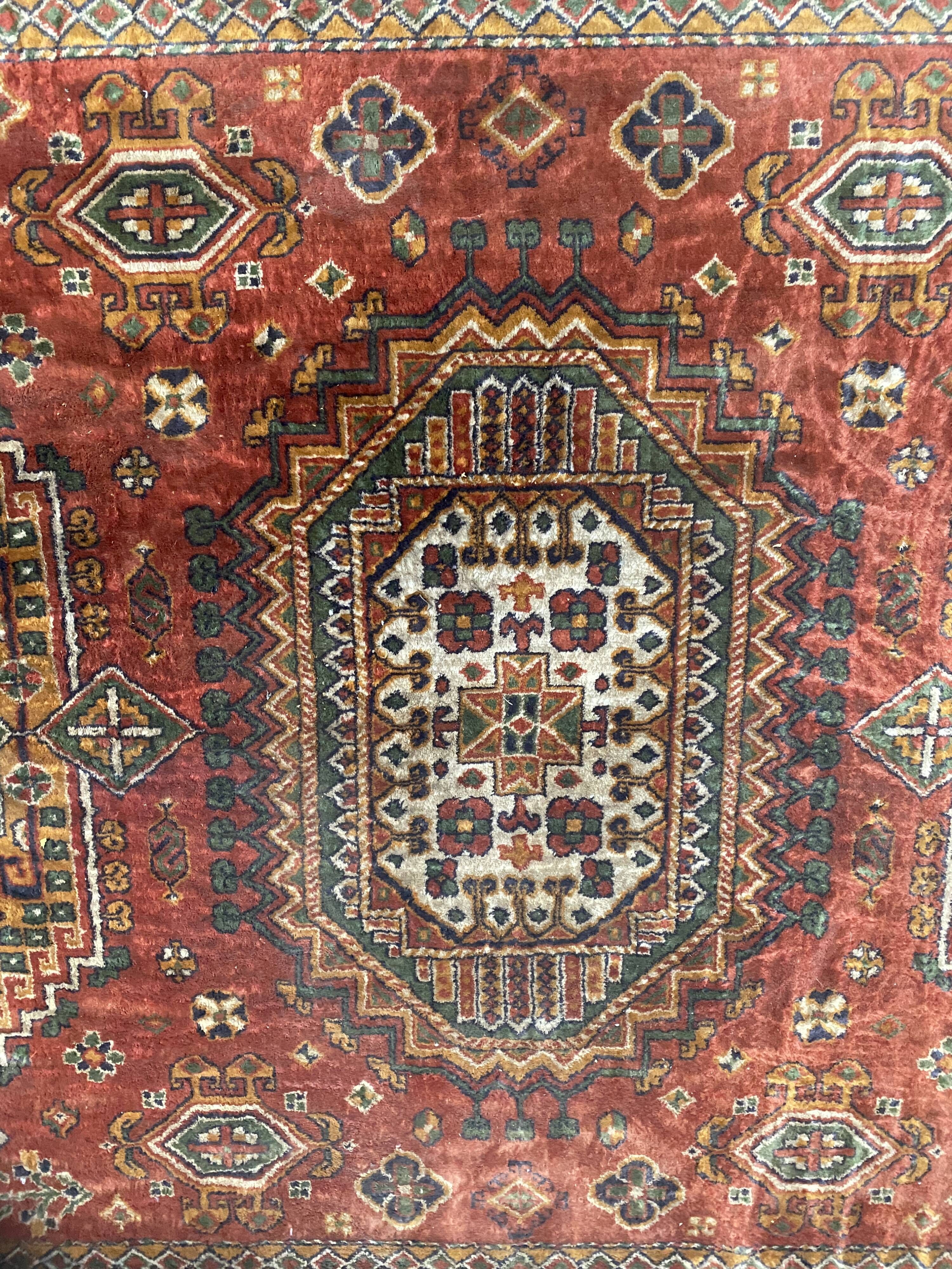 Antique wool rugs with designs on a red background, 20th century.