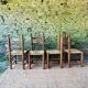 Set of 4 solid wood chairs with straw seats.