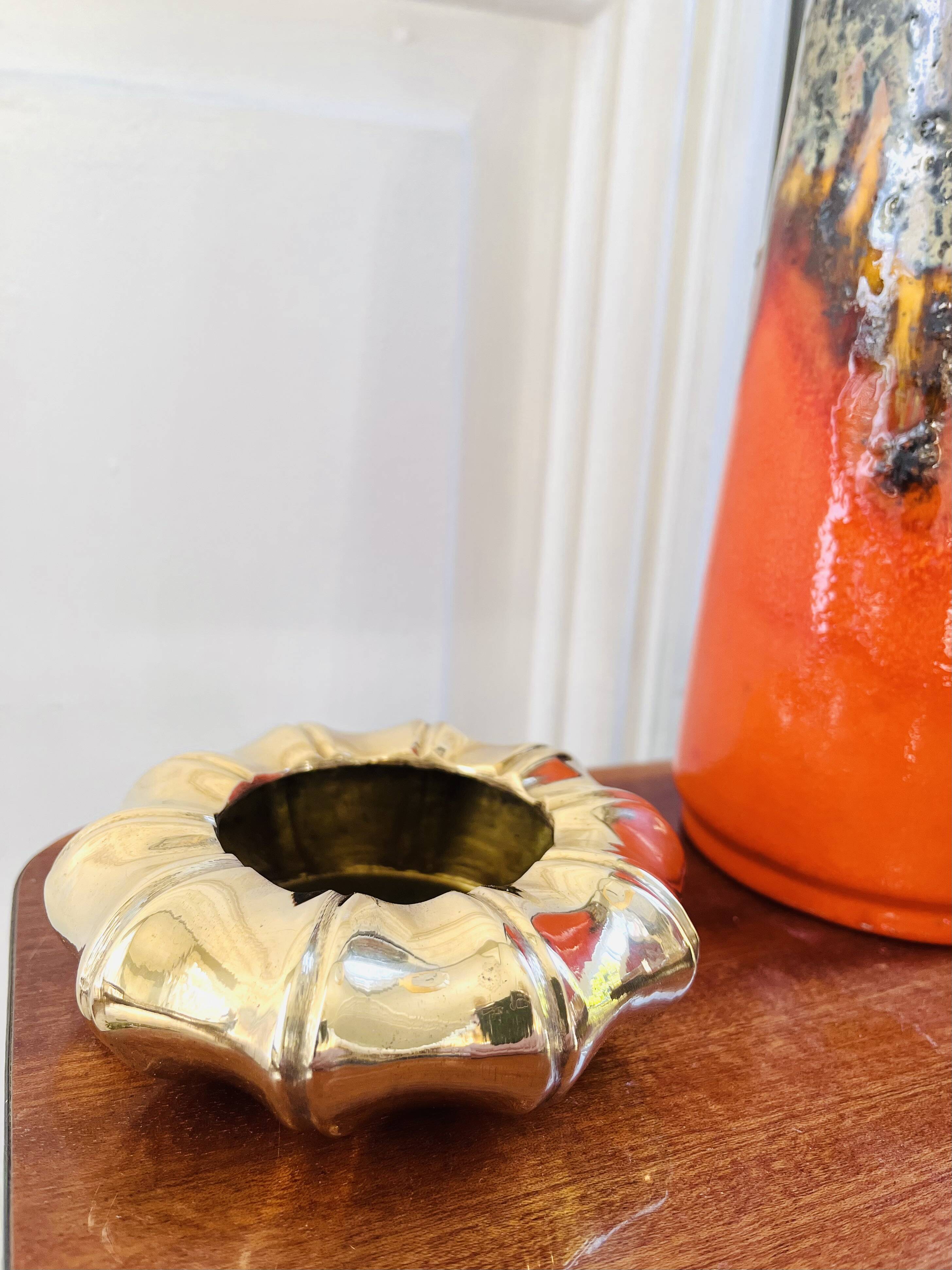 Golden brass ashtray with bamboo decoration.