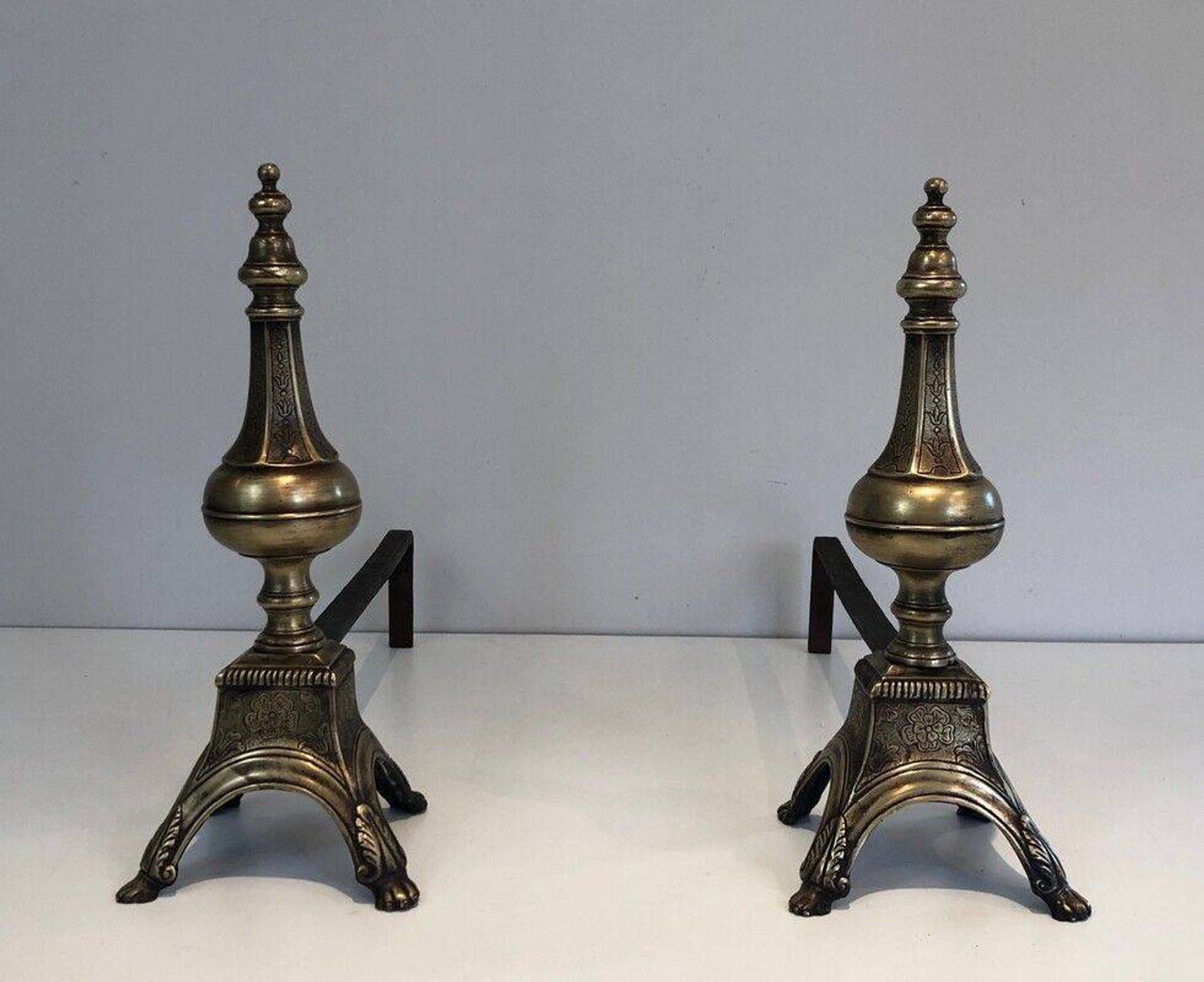 Pair of chiselled bronze and wrought iron fire dogs in the Louis XVI style.