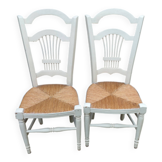 Pair of straw-seated chairs with white-stained wood.