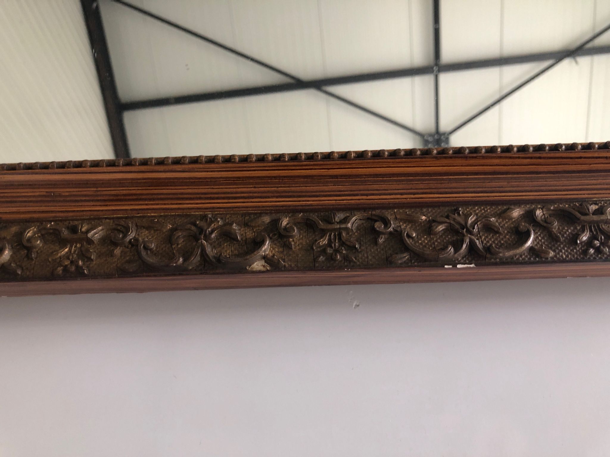 Old mirror with wooden frame and plaster moldings