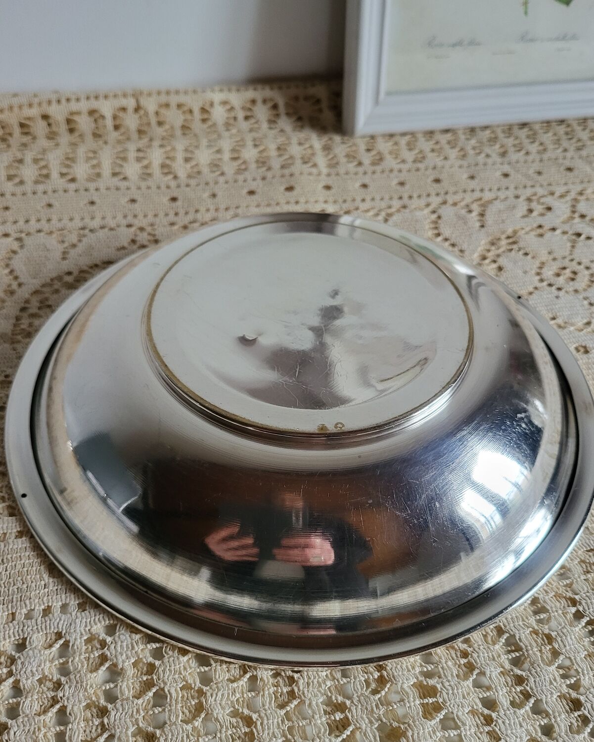 Shallow round metal plate with pearl bead decoration.