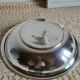 Shallow round metal plate with pearl bead decoration.