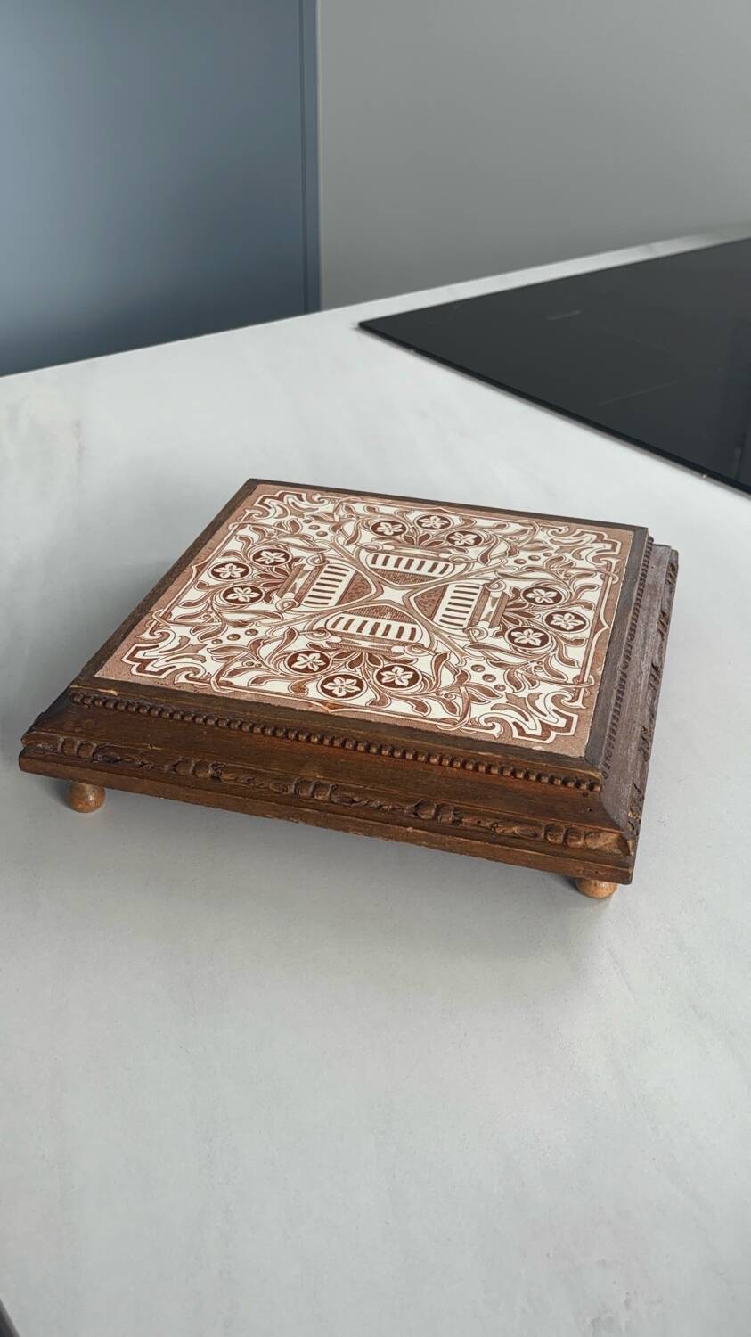 Vintage wooden and antique earthenware trivet, brown tile design