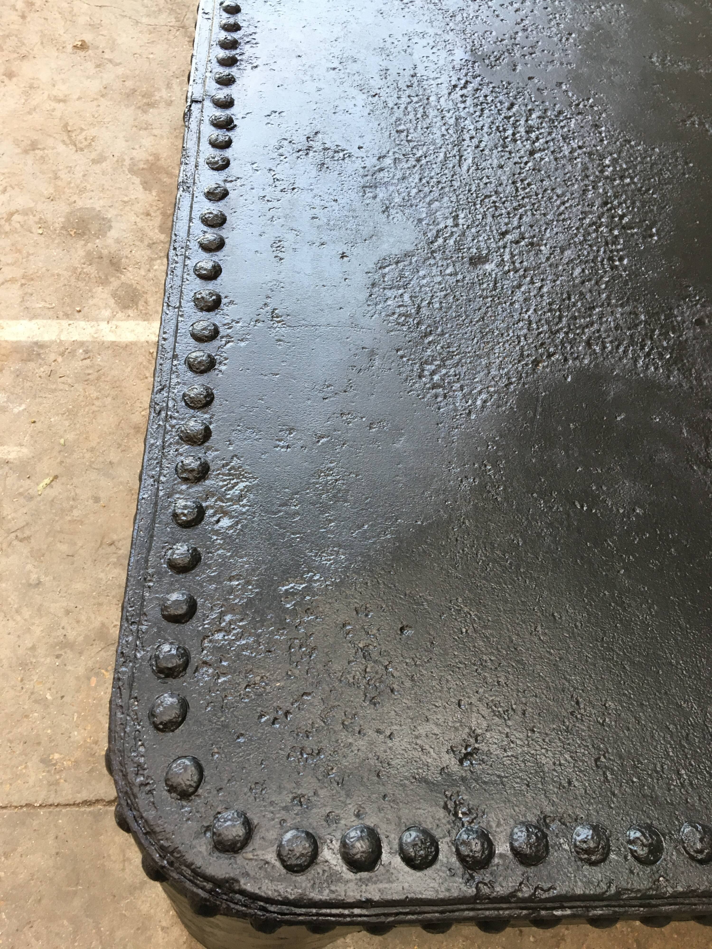 large industrial table in graphite black riveted metal