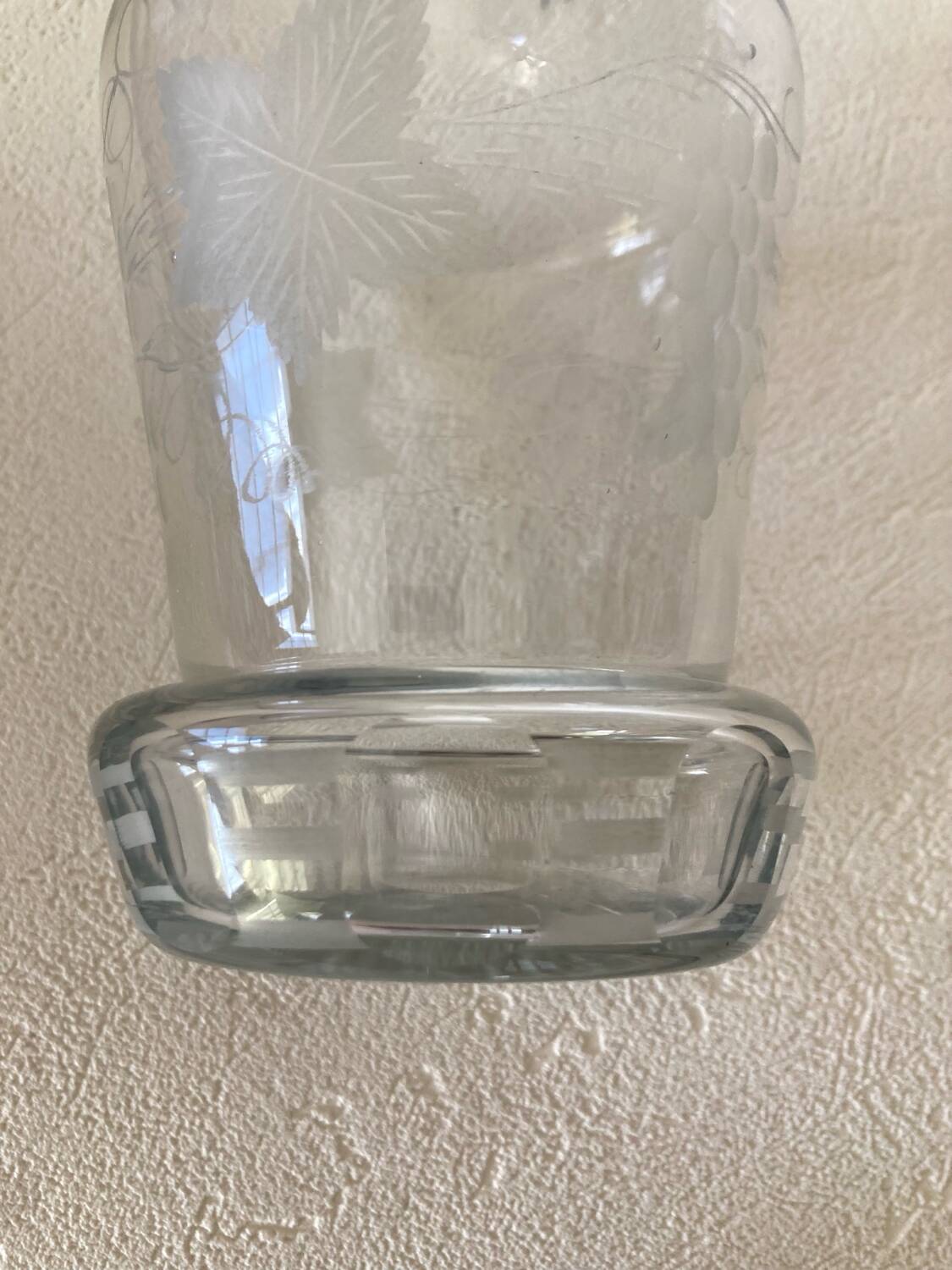 Small carafe in blown cut glass with engraved decoration of vine leaves and grapes, threaded stopper