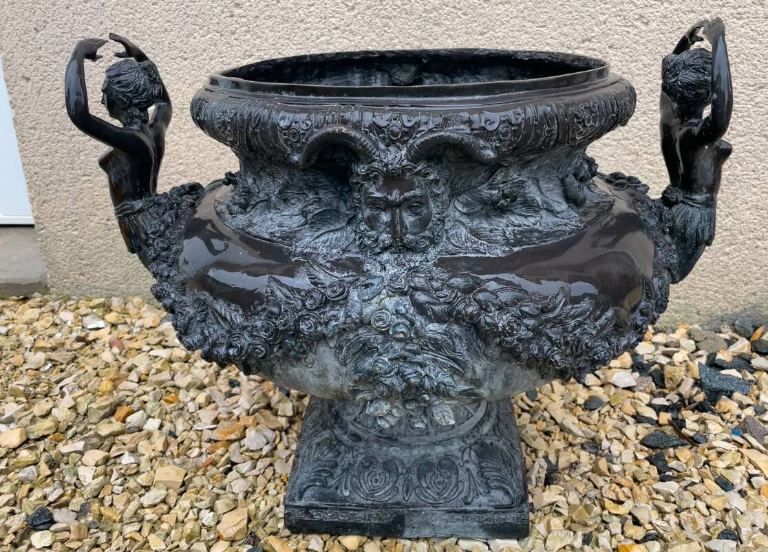 Cast iron vase decorated with mermaids.