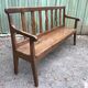 Duo of old solid oak benches with backs and armrests.