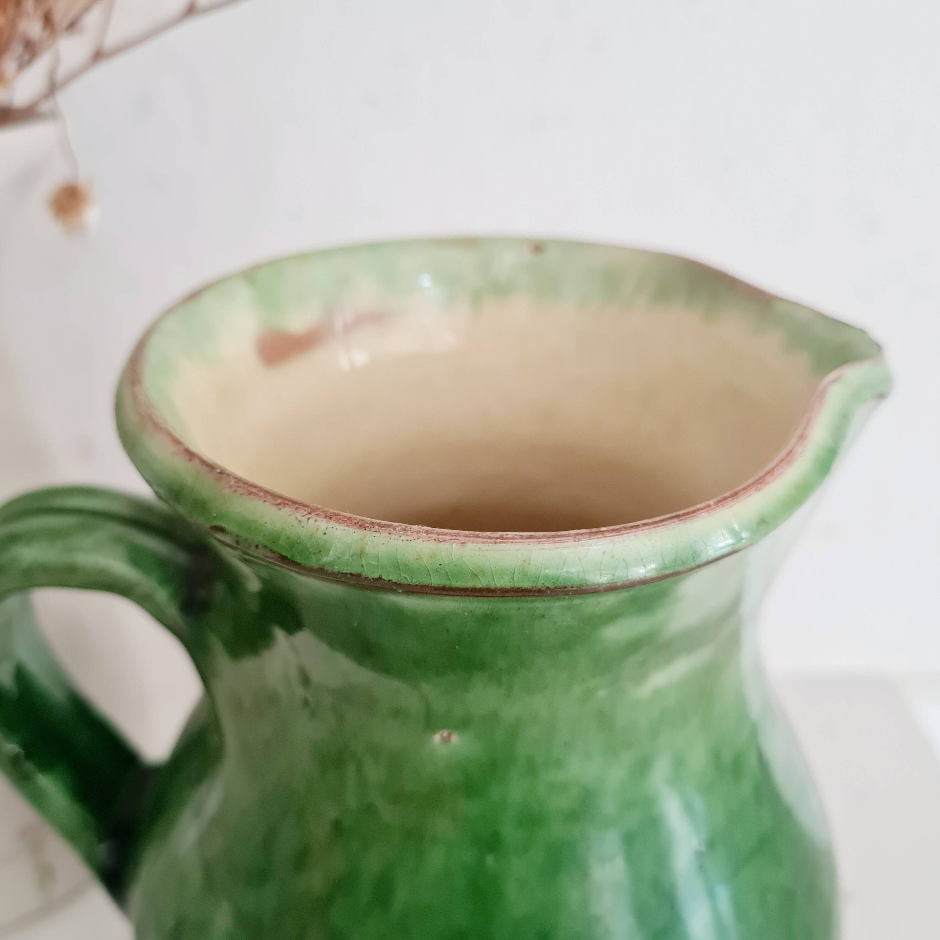 Antique green pitcher in painted terracotta