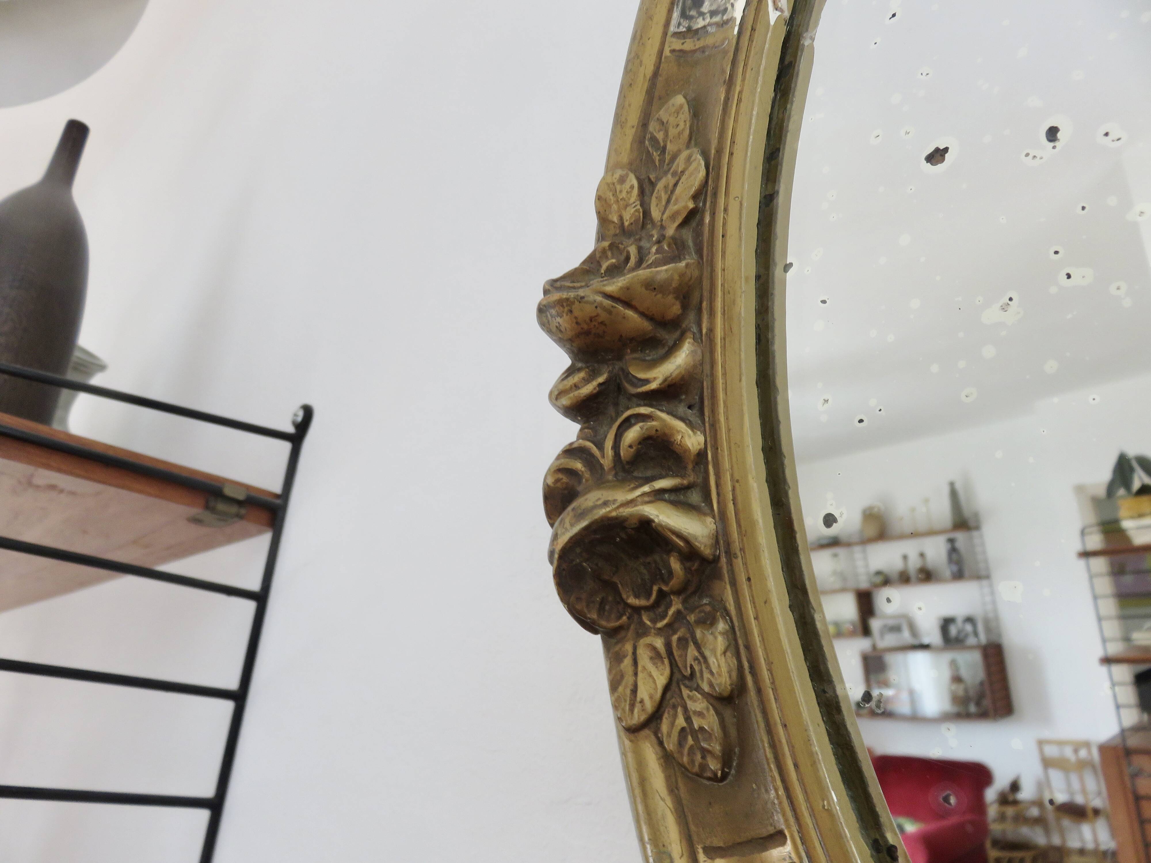Oval wall mirror, golden floral pattern in stucco and wood, late 19th century