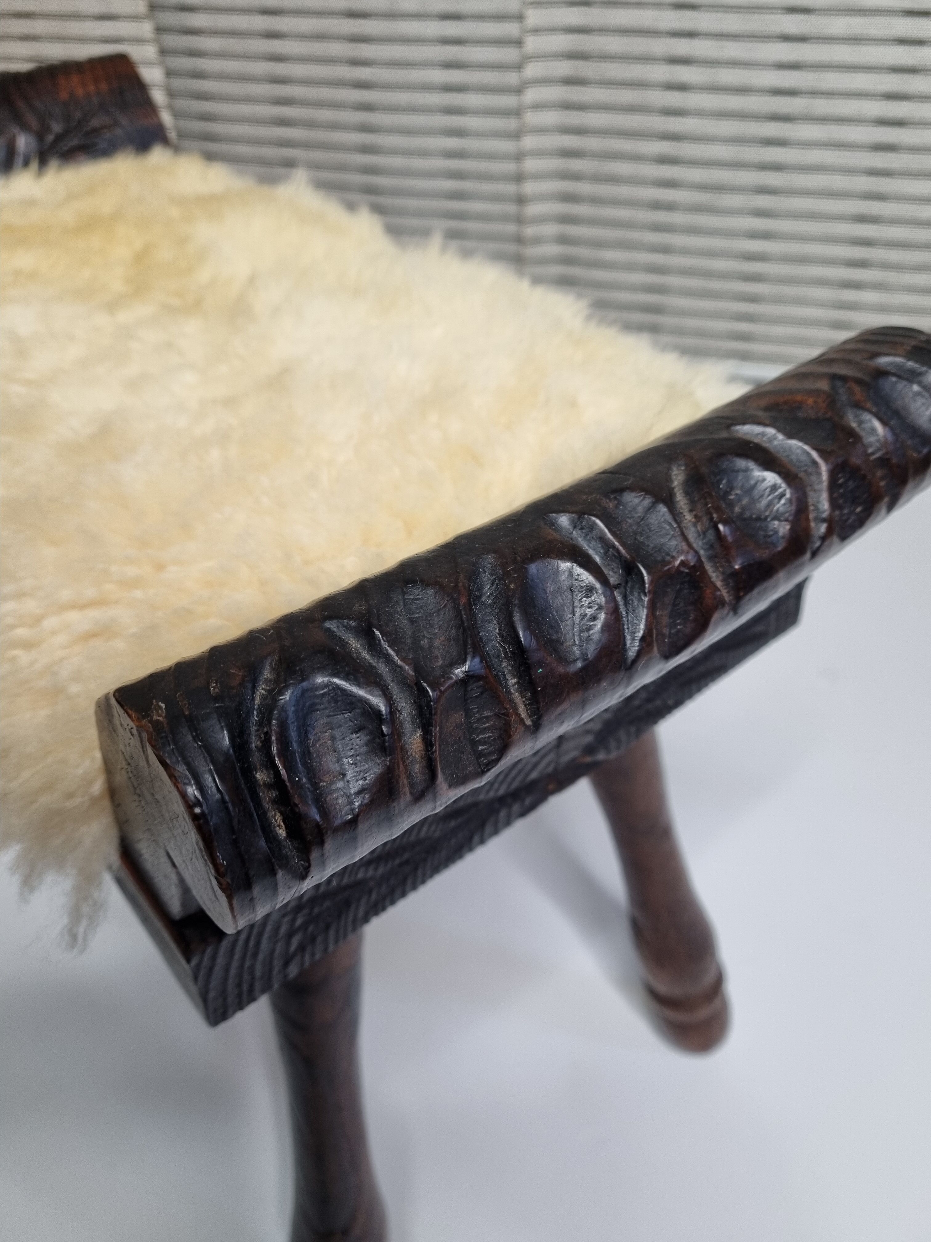 Carved wooden stool covered with Celtic-style sheepskin