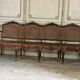 Grande banquette Louis XV en bois naturel mouluré et sculpté, France XVIIIème siècle