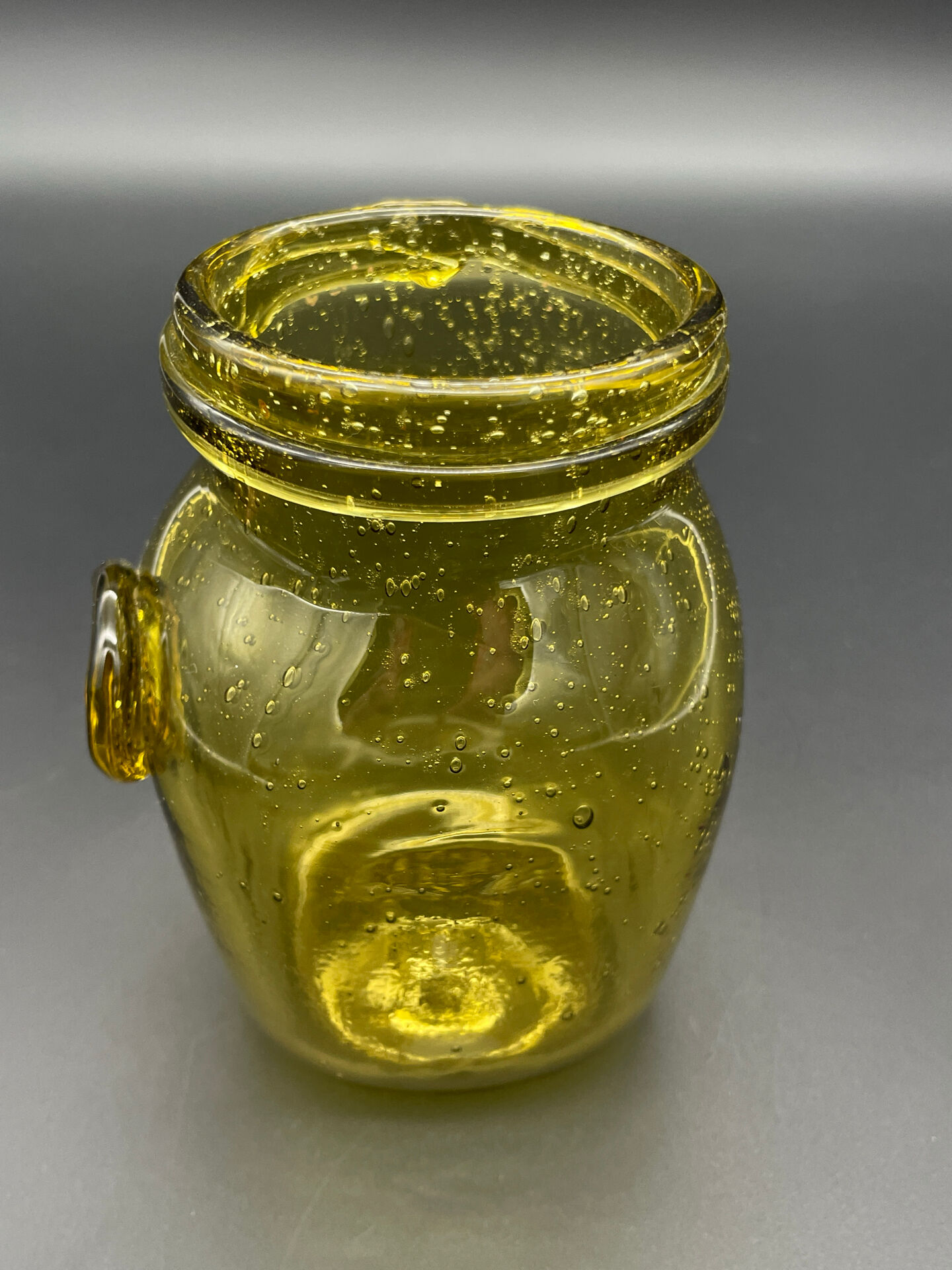 Yellow bubbled glass apothecary jar with cork lid.