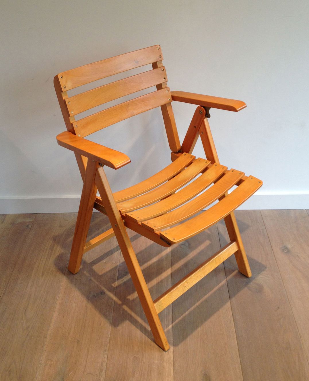 Pair of varnished wooden folding armchairs signed Clairitex.