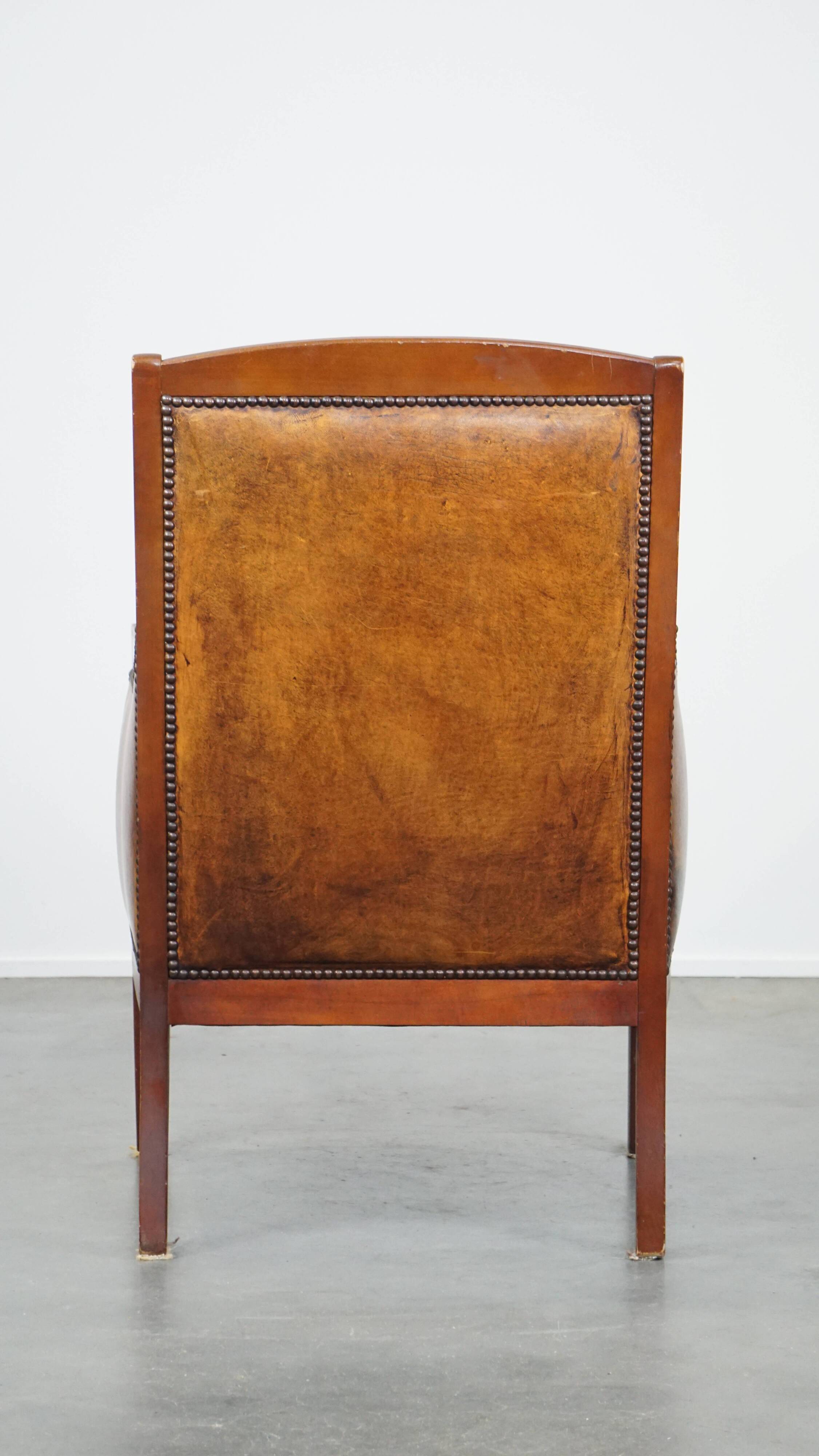 Sheepskin and wooden vintage Art Deco design armchair in a cognac color