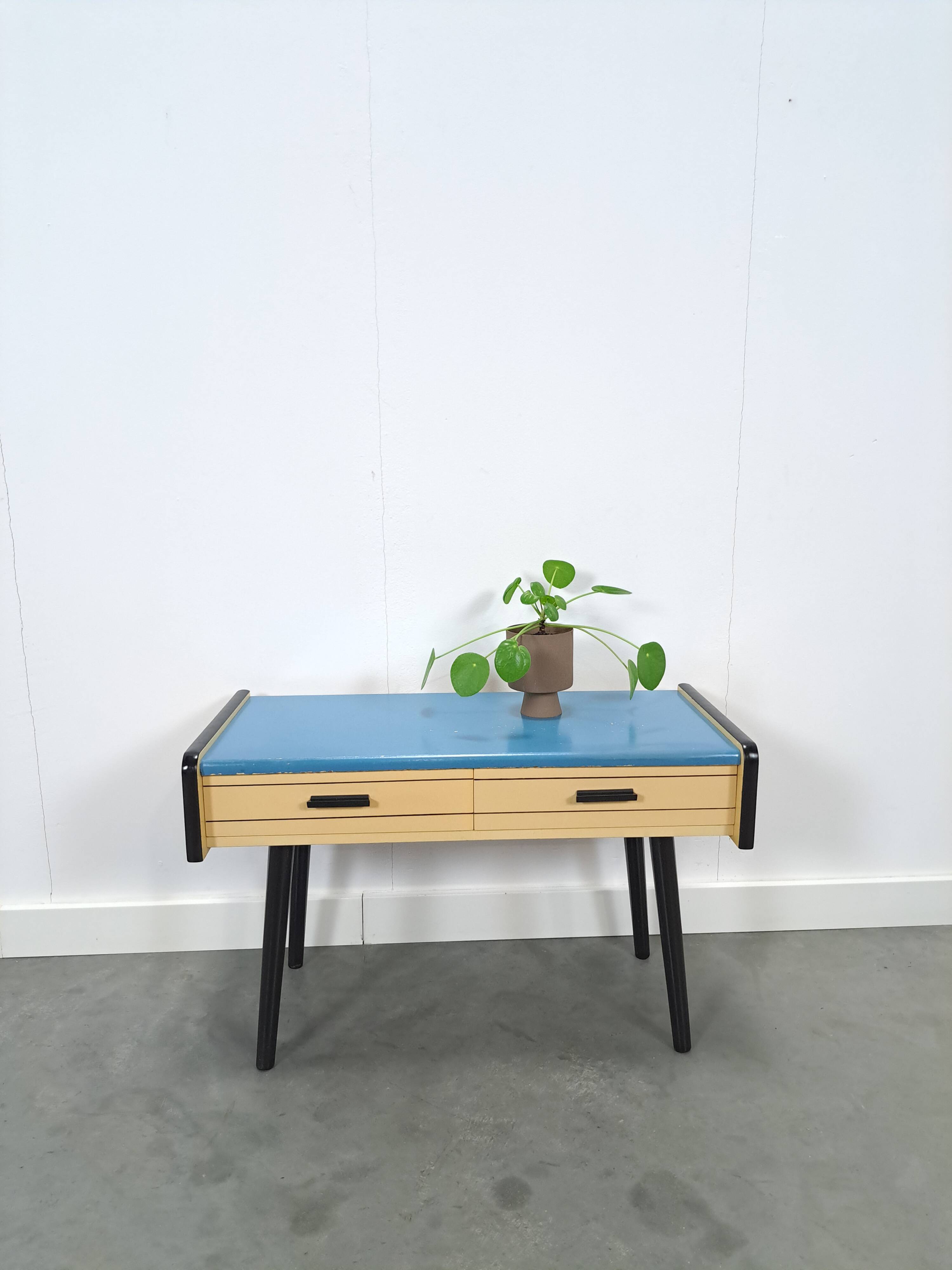 Jaren 50 ladekastje met blauw blad en zwarte poten