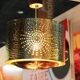 Hammered copper metal pendant light with a golden cylindrical shade.