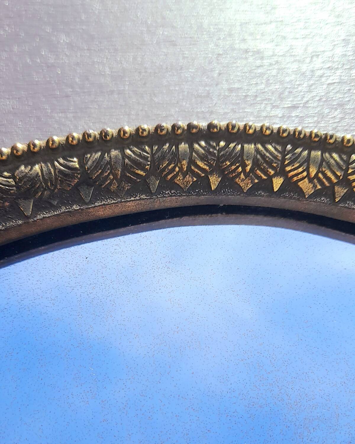 Oval mirror in gold metal