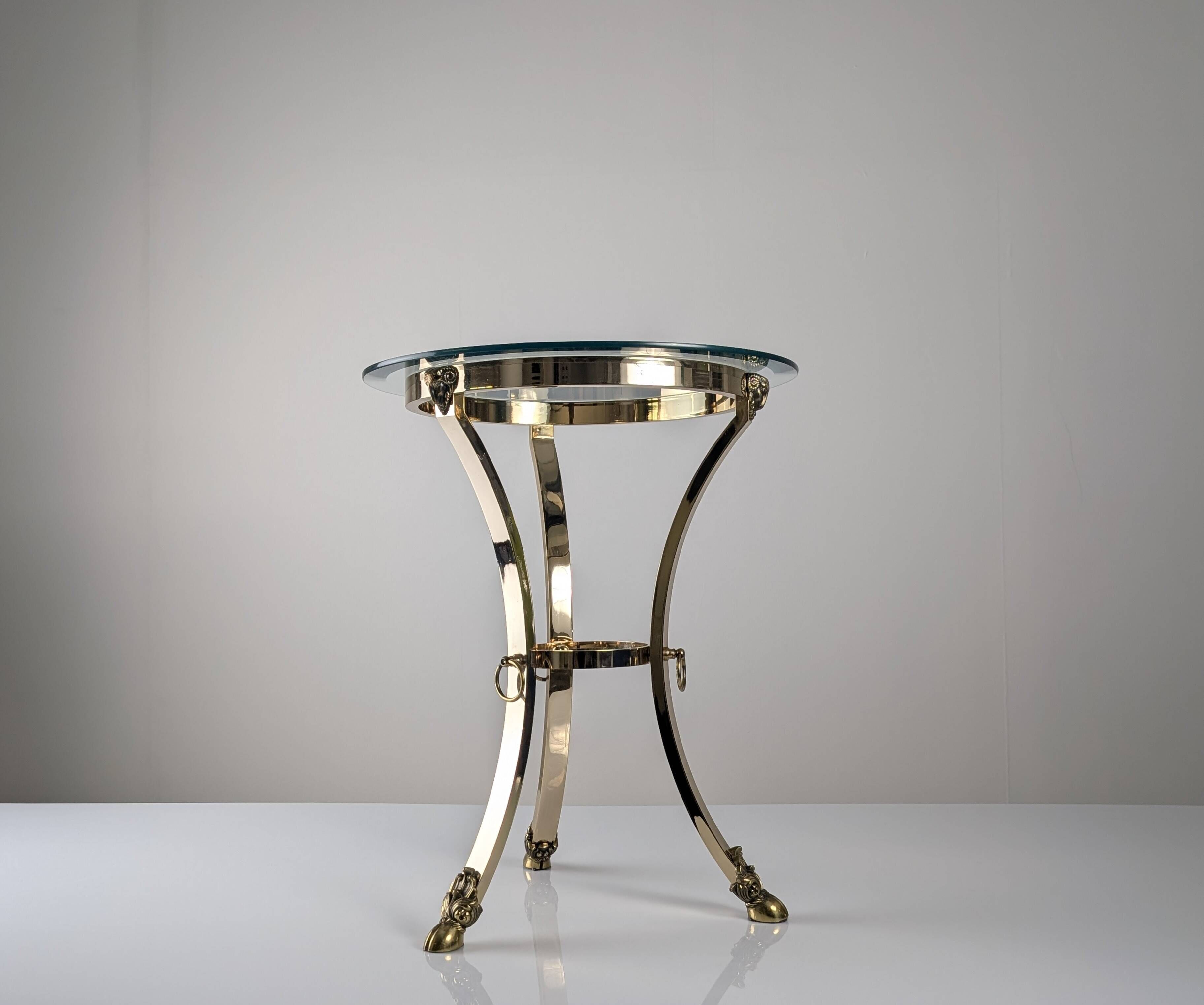Neoclassical side table in brass and bevelled glass with ram's heads, 1970s.