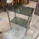 Serving dessert trolley with 2 smoked glass shelves and metal structure.