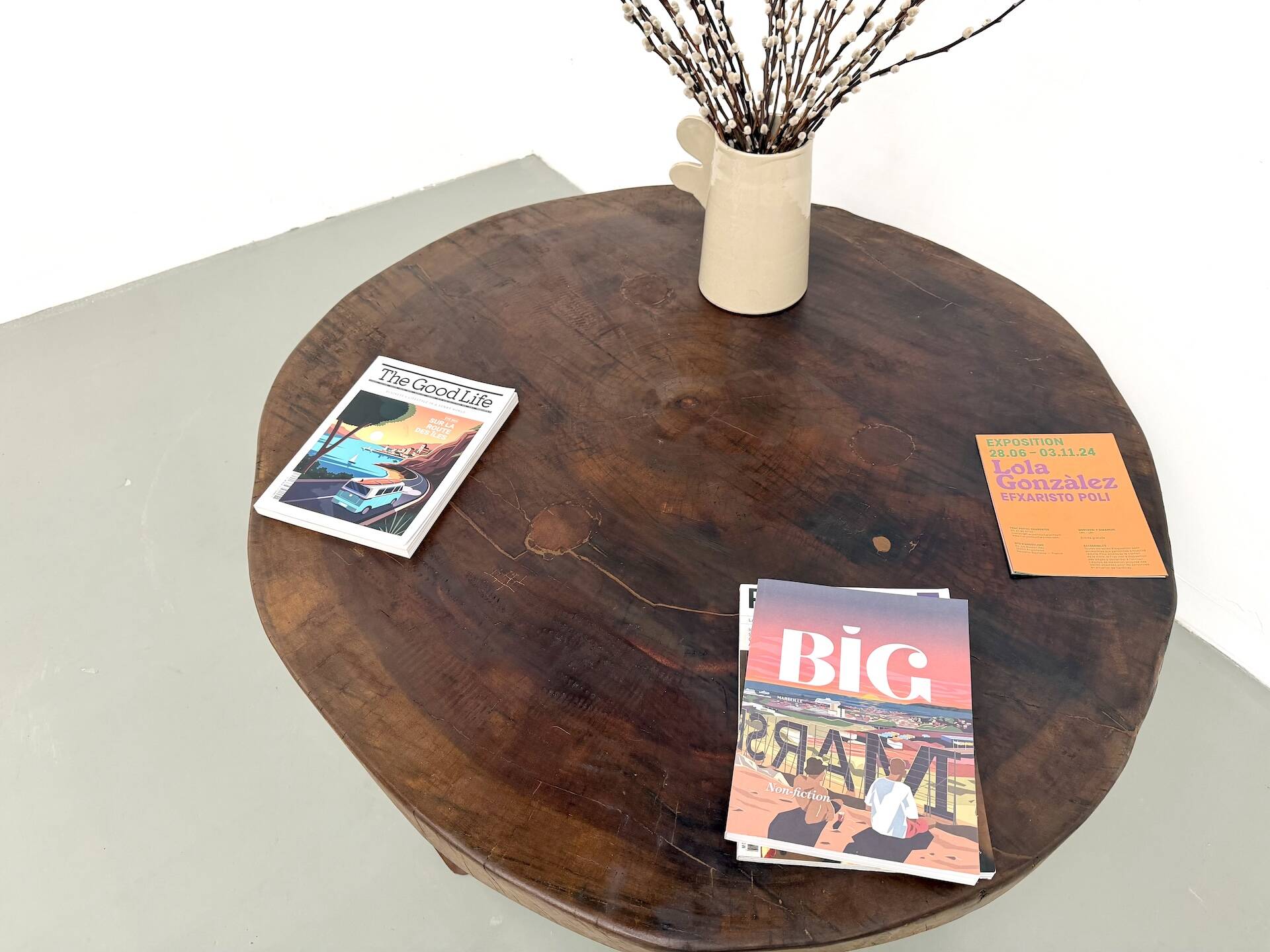 Brutalist coffee table in solid teak, monolithic slab, tripod base.