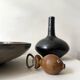 Glazed black ceramic vase with a single stem, signed, circa 1950.