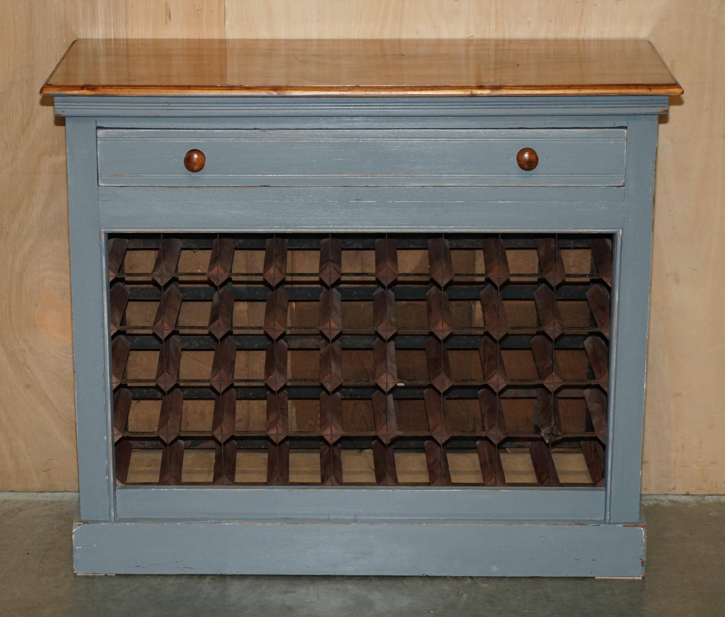 Vintage wooden furniture for 45 wine bottles with a drawer.