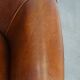 Sheep leather club chair in a cognac color and finished with piping