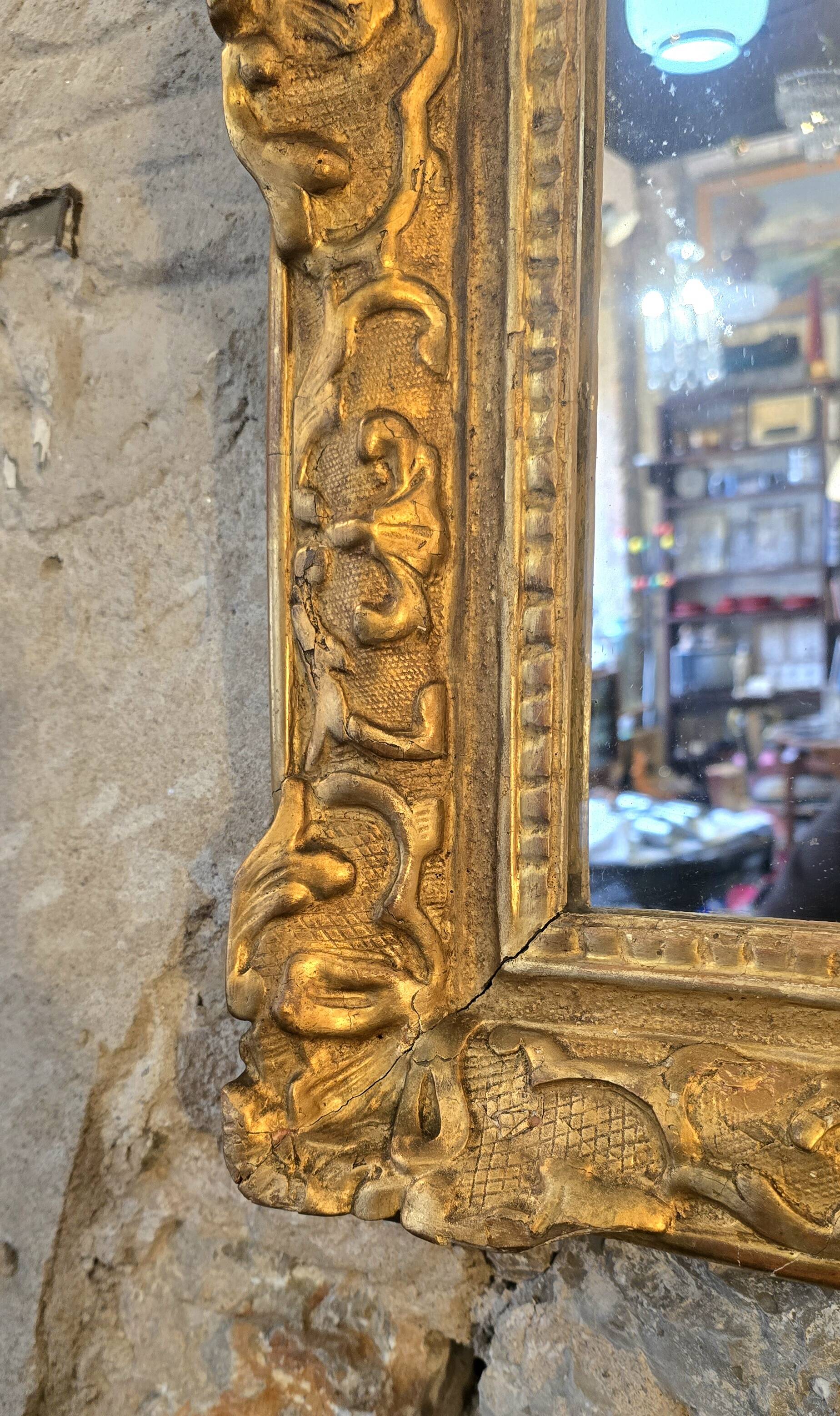 Miroir d’époque Régence à fronton en bois sculpté et doré  – XVIIIe