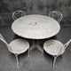Antique painted wrought iron garden furniture, round table and four chairs.