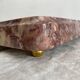 Pink marble trivet with brass ball feet.