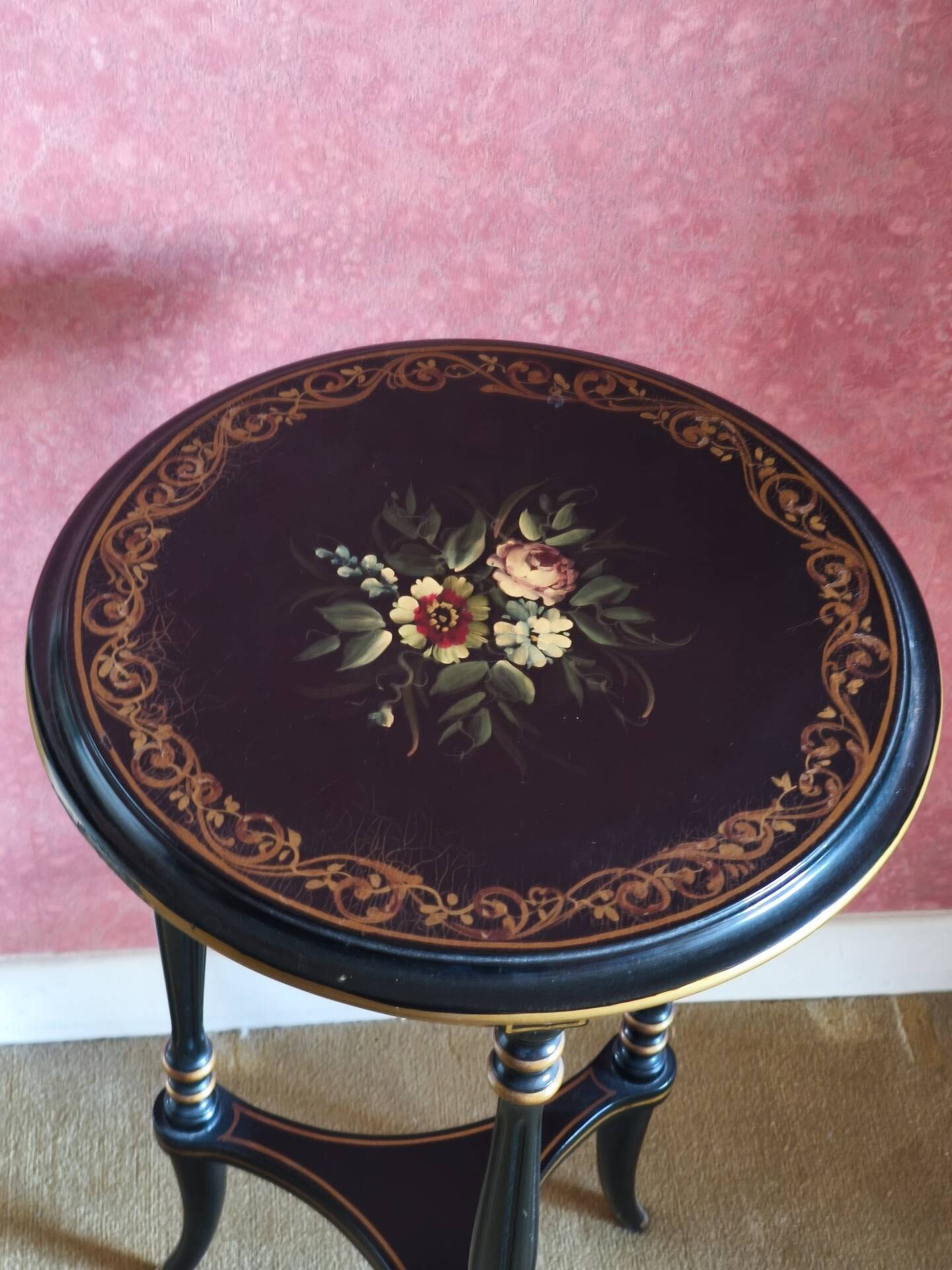 Tripod stool in blackened wood with painted floral decoration.
