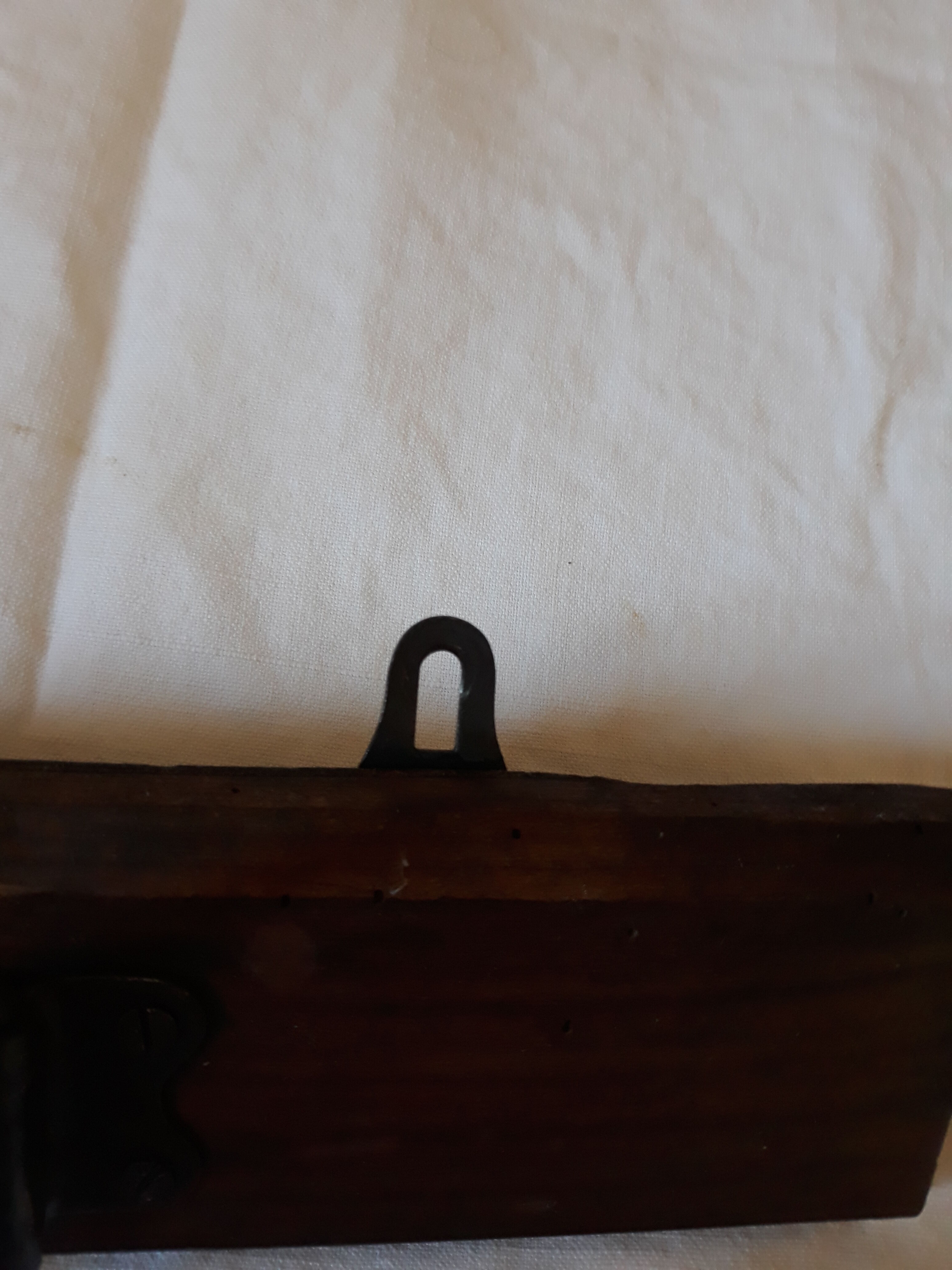 old wall coat holder made up of 3 wooden and metal pads.