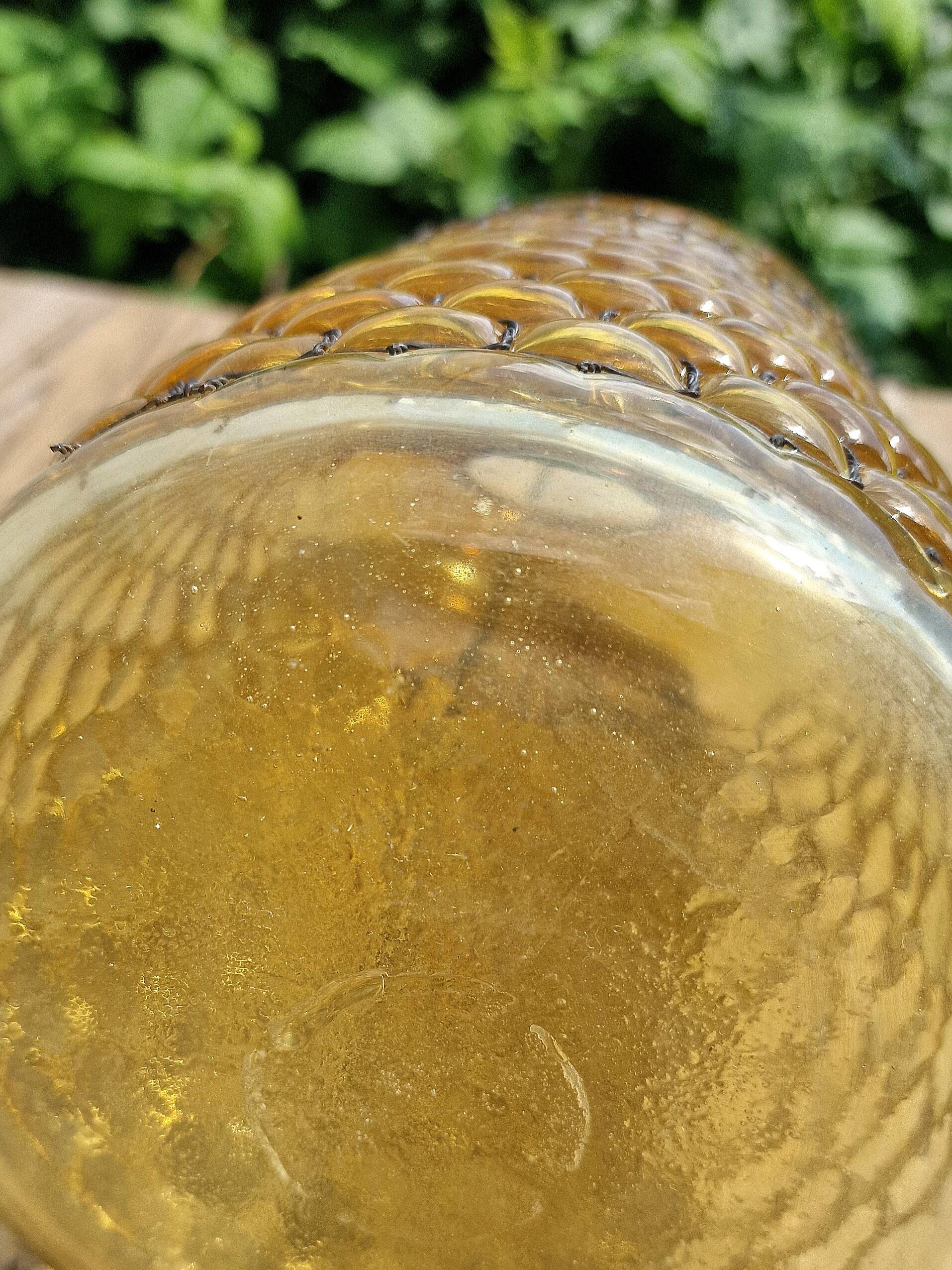 Artisanal blown amber glass vase with integrated honeycomb structure.