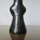 Matte black ceramic sculpture representing a female tribal figure.