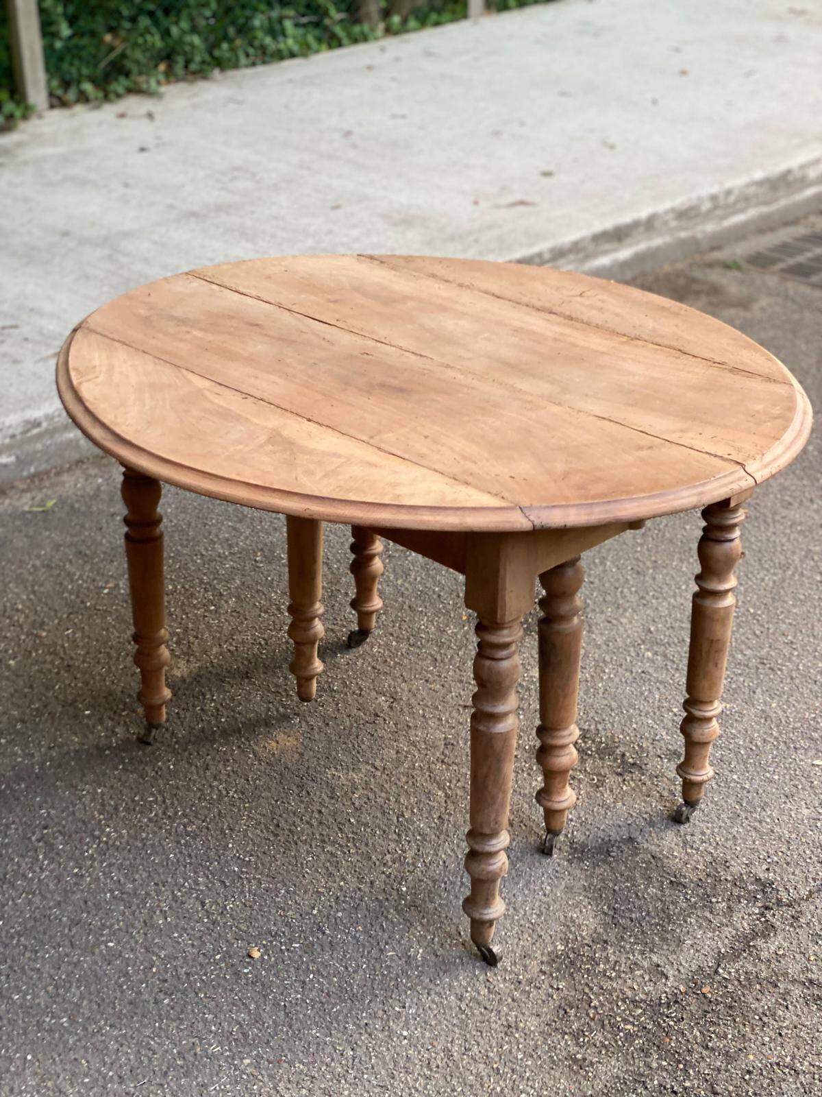 Renovated round extendable dining table with leaves made of solid wood.