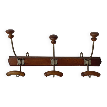 Old wooden and metal wall-mounted coat rack.