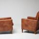 Pair of Art Deco armchairs in brown leather and teak, Netherlands, 1970s.