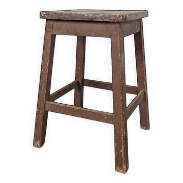 Brown painted wooden workshop stool with a patinated top.