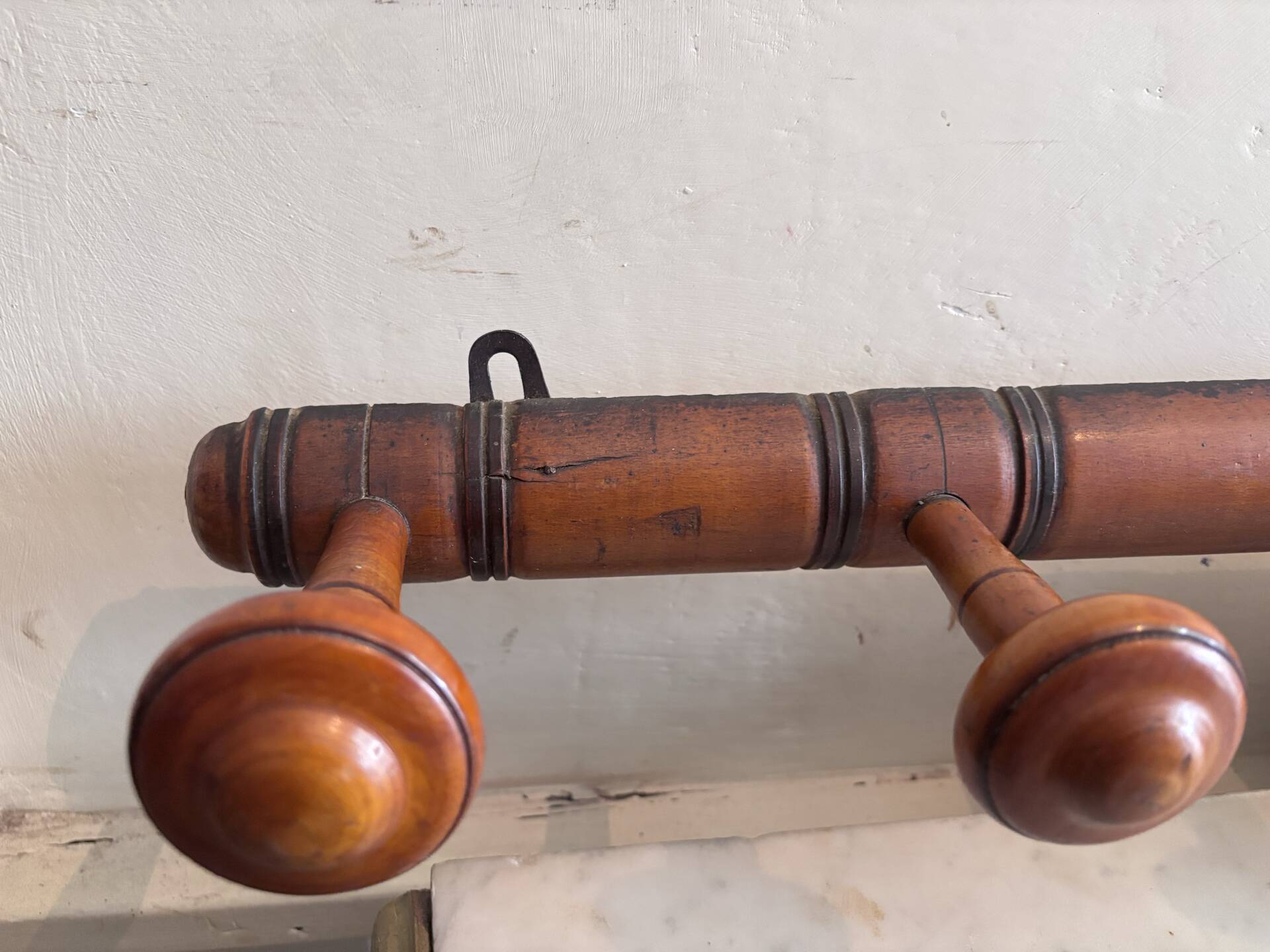Wall-mounted coat rack with 8 turned wooden hooks in faux bamboo style.