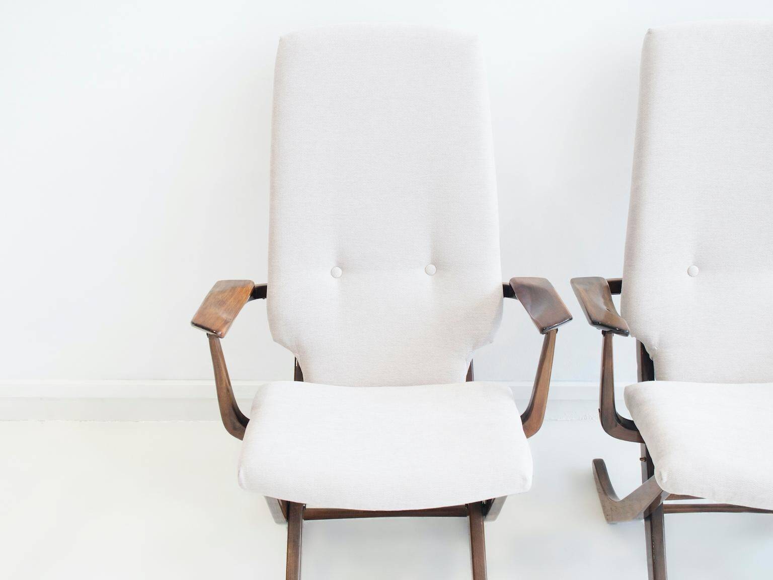 Pair of varnished wooden reclining armchairs, upholstered in lightweight fabric.