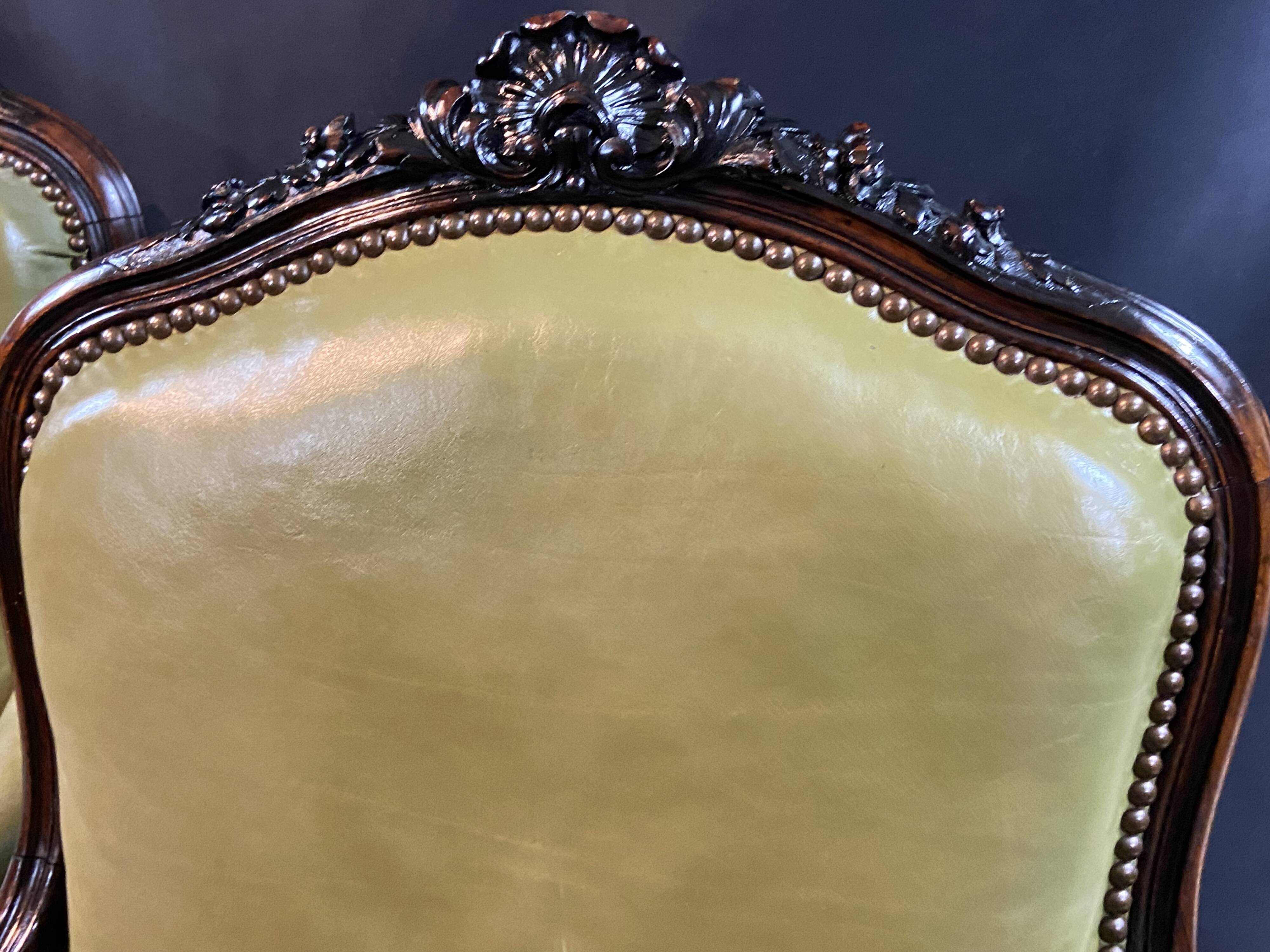 Paire de larges fauteuils XIXe en cuir vert de style Louis XV