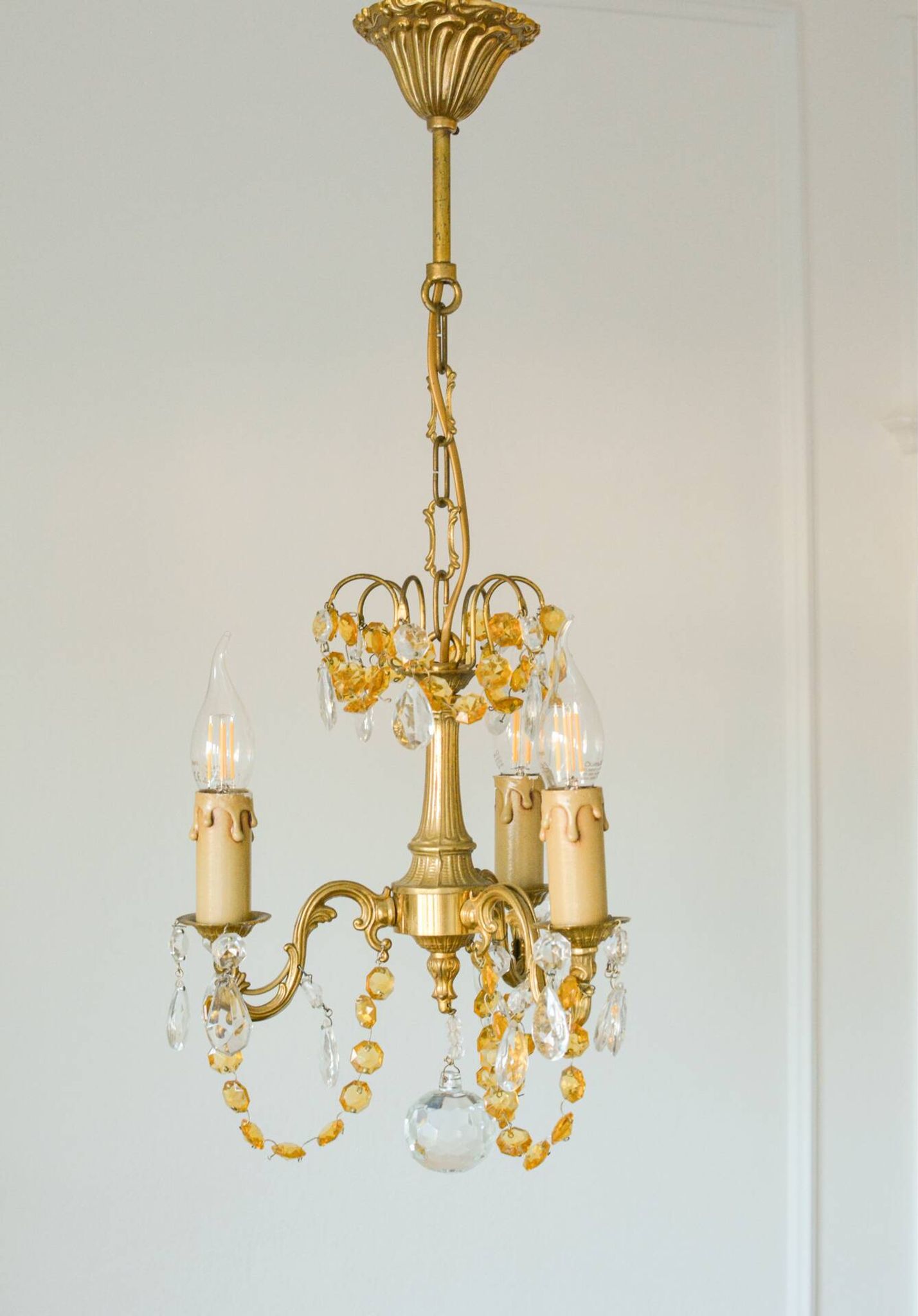 Small vintage brass chandelier with amber crystal pendants.