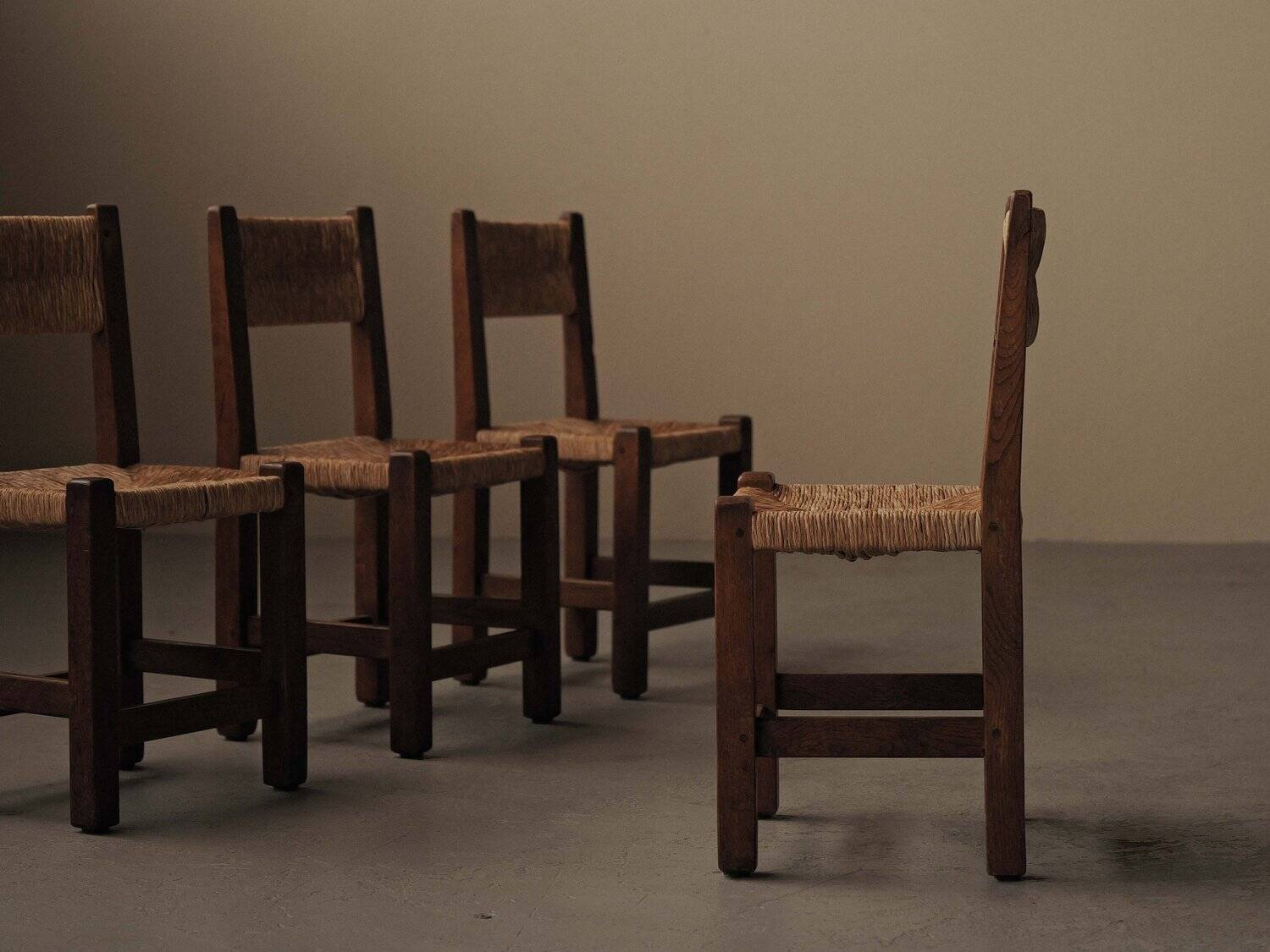 Set of four modernist chairs in oak and straw, France, circa 1960.