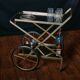 Vintage rolling trolley in gold metal & smoked glass – Retro elegance as