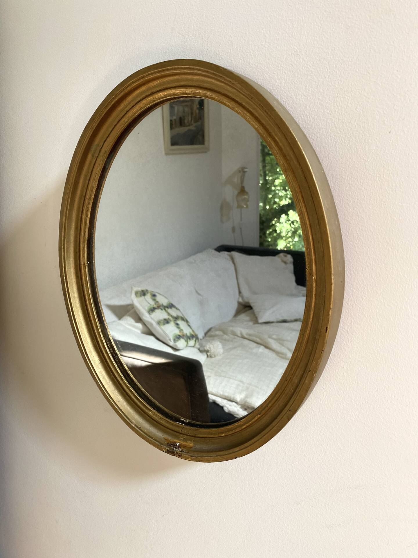 Oval mirror in gilded wood