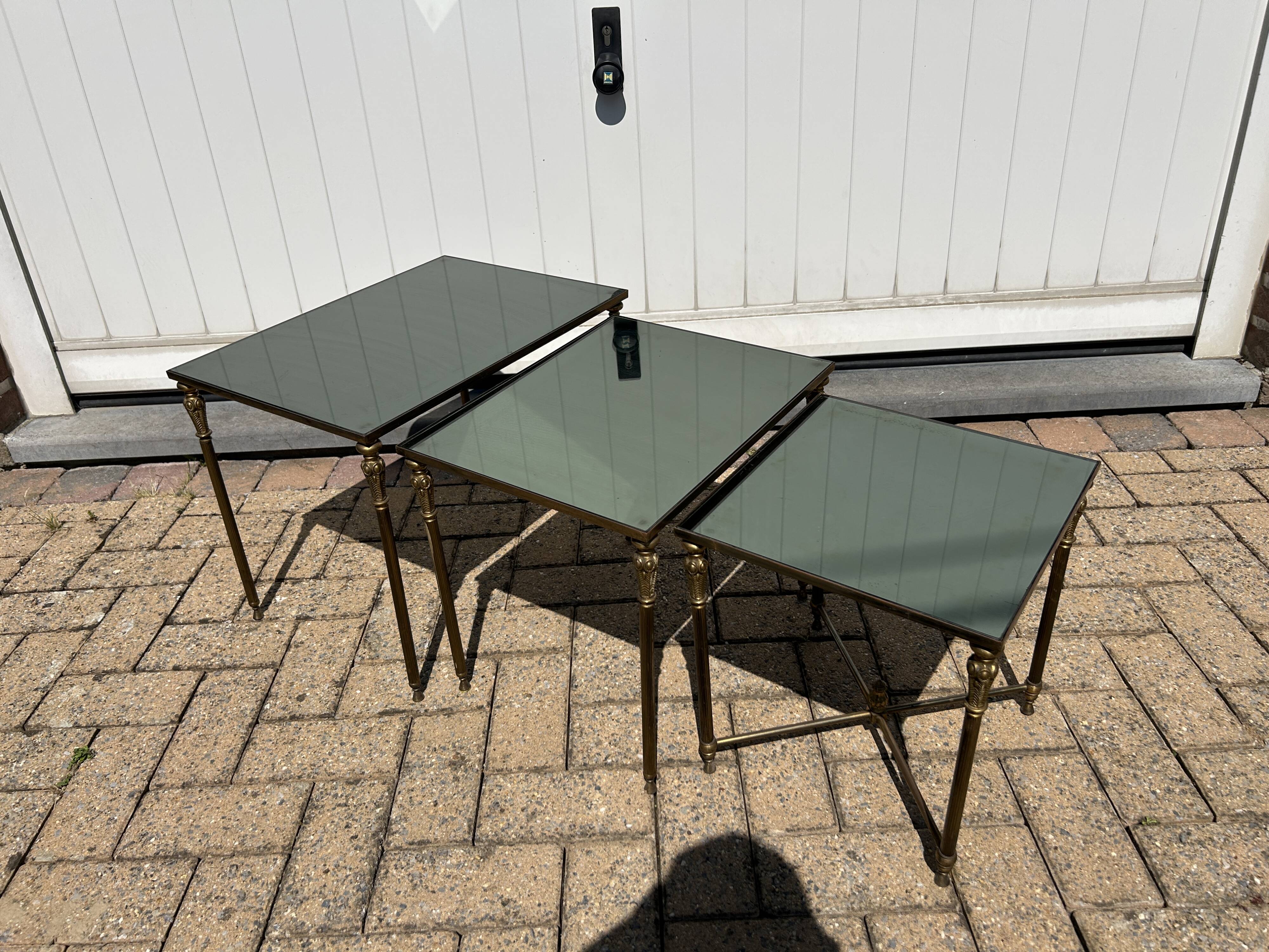 Nested tables in gilded brass in the style of Maison Charles.