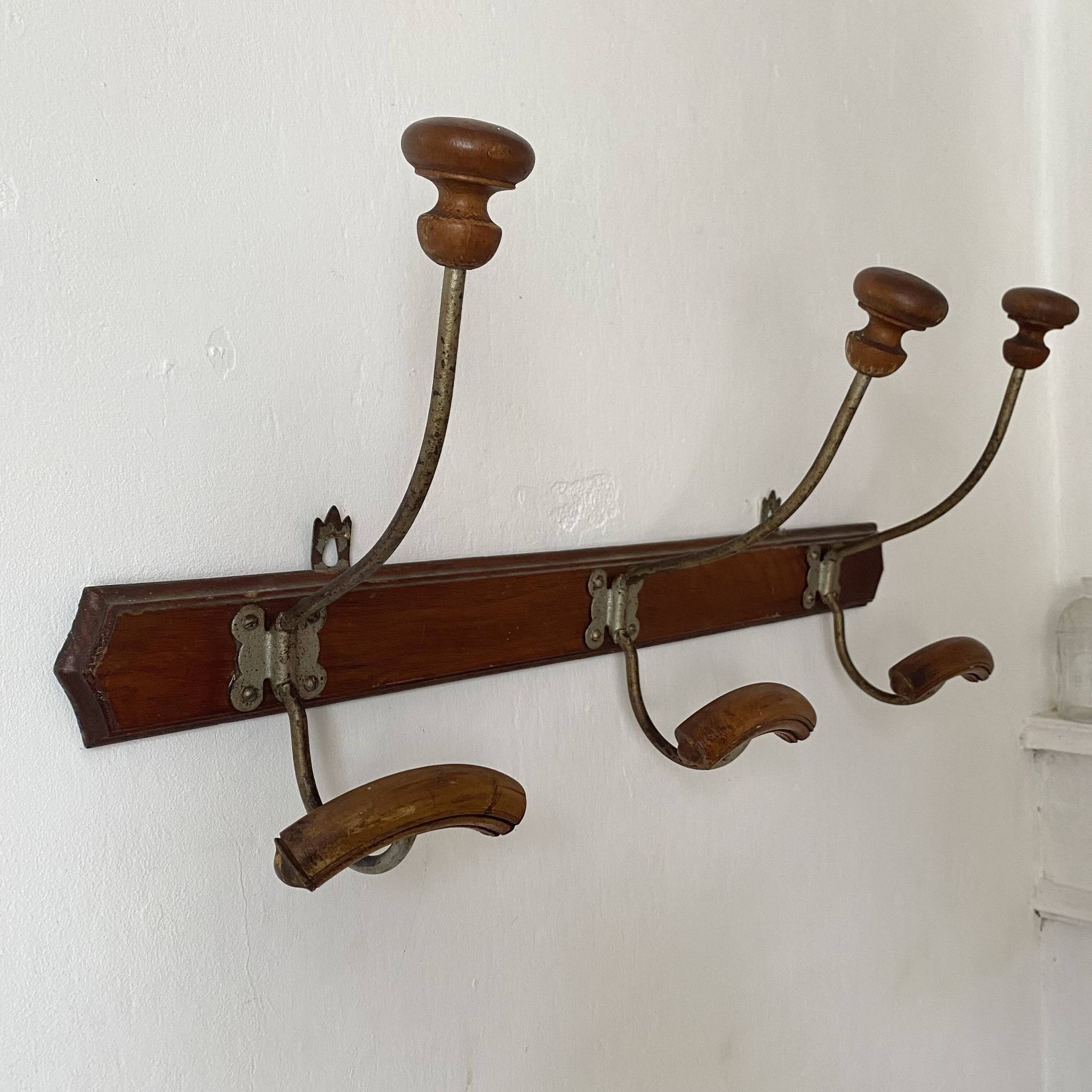 Old wooden and metal wall-mounted coat rack.