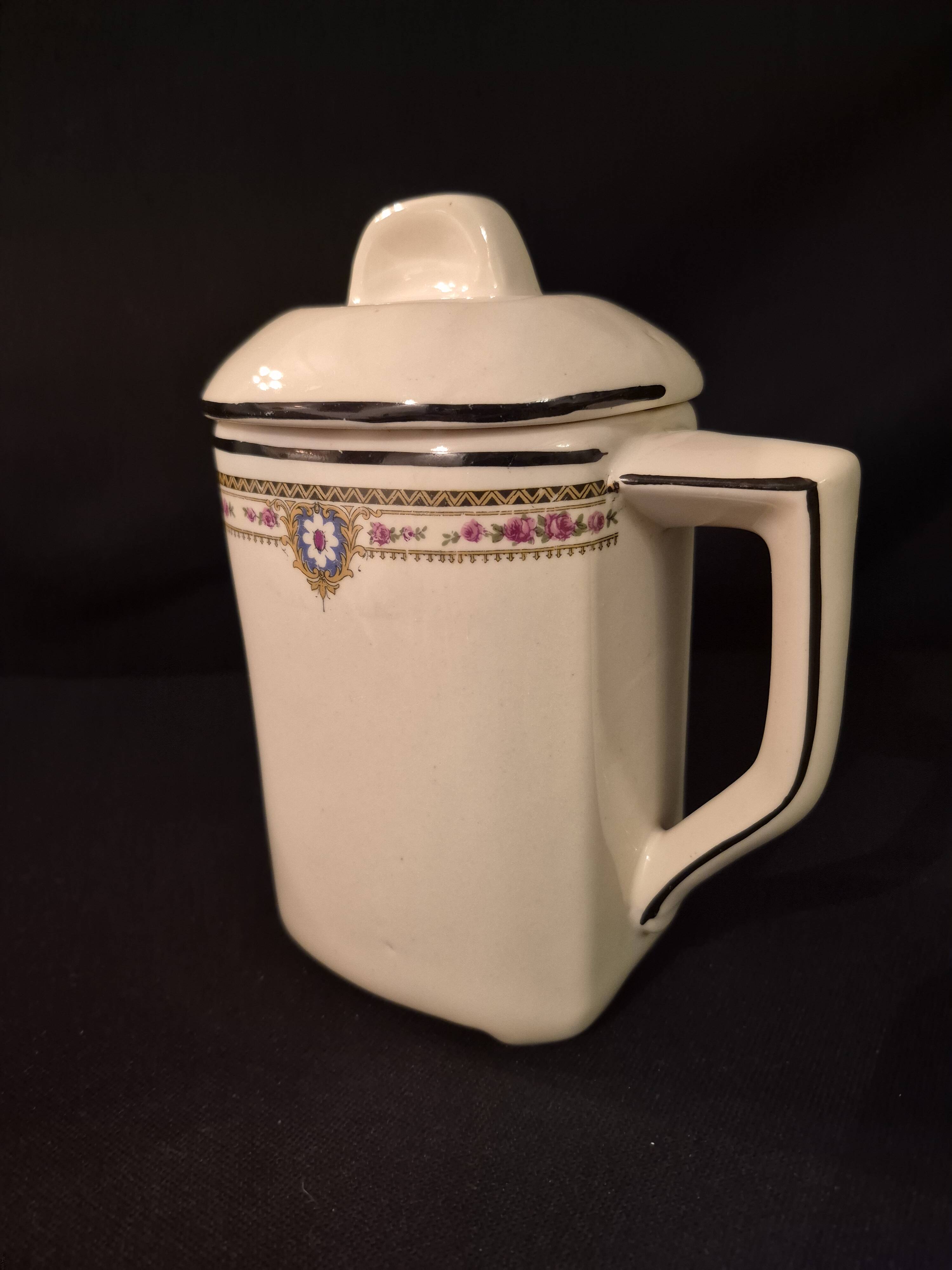 Old covered jug, vintage, geometric frieze with flowers and black trim.